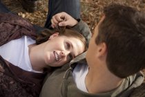 Beautiful woman relaxing on boyfriend knees at park — Stock Photo