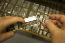 Imagen recortada de manos masculinas en el proceso de impresión de Letterpress - foto de stock