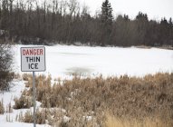 Firma che dice pericolo sottile ghiaccio — Foto stock