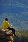 Uomo seduto sulla montagna — Foto stock