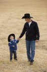 El hombre y su hijo con sombreros de vaquero - foto de stock