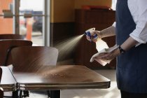 Person Cleaning Tables at cafe — Stock Photo