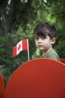 Хлопчик тримає Канадський прапор на відкритому повітрі — стокове фото