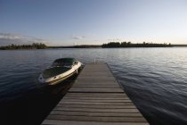 Boot auf dem Wasser neben Dock, See des Waldes, Ontario, Kanada — Stockfoto