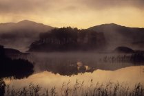 Montagne e lago nella nebbia — Foto stock