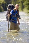 Homme Randonneur traversant la rivière. Kananaskis, Alberta, Canada — Photo de stock