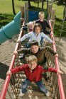 Cinq enfants s'amusent sur une aire de jeux — Photo de stock