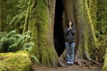 Mujer meditando por el abeto Douglas. Parque Provincial Macmillan, Vancouver, Canadá - foto de stock