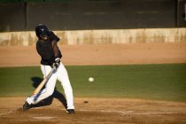 Giocatore di baseball professionista oscillando il suo pipistrello — Foto stock