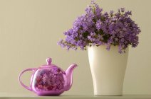 Tetera y flores en un jarrón - foto de stock