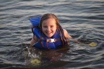 Mädchen im Wasser mit persönlichem Schwimmgerät — Stockfoto