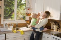 Caucasico madre e bambino figlia abbraccio su cucina e avendo divertimento — Foto stock