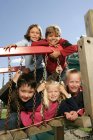 Cinque bambini si divertono sul campo da giuoco — Foto stock