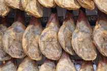 Gambe di prosciutto di montagna salato e essiccato in vendita nel supermercato — Foto stock