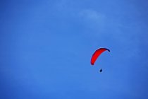 Parasailing en el cielo azul en Devon, Inglaterra - foto de stock