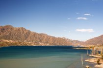 A Lake Surrounded by Colourful Desert Mountains; Potrerillos, Mendoza, Argentina — стоковое фото