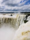 Великий водоспад з сильним водяним потоком на тлі похмурого неба — стокове фото