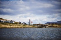 Chiesa con tetto rosso, fienile e fattoria lungo un lago; Islanda — Foto stock