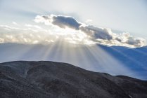Lichtströme hinter einer Wolke im Death-Valley-Nationalpark, in der Nähe von Künstlern; Kalifornien, Vereinigte Staaten von Amerika — Stockfoto