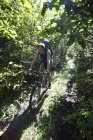 A Woman Mountain Bikes Down A Trail With A Backpack; Alaska, Estados Unidos da América — Fotografia de Stock