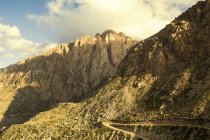 Estrada da sujeira em um lado da montanha na Cordilheira dos Andes ao pôr do sol; Mendoza, Argentina — Fotografia de Stock