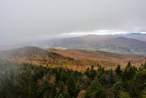 Chuva cai de nuvens pesadas sobre uma floresta colorida de outono nas montanhas; Dunham, Quebec, Canadá — Fotografia de Stock