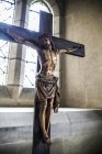 Crucifixión contra la ventana con luz solar durante el día en el interior de la iglesia - foto de stock