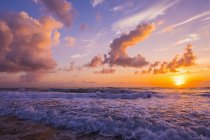 Вид на хмарне небо і великий захід сонця над хвилястою морською водою — стокове фото