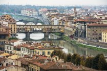 Vue Des Bâtiments, Des Toits Colorés, Des Ponts Anciens (Ponte Vecchio) Et De La Fleuve Arno Pliante ; Florence, Toscane, Italie — Photo de stock