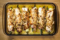 Glass Casserole Dish On Wooden Cutting Board Filled With Rolled Browned Chicken Stuffed With Asparagus In A Cream Sauce; Calgary, Alberta, Canada — Stock Photo