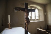 Crucificação contra janela durante o dia no interior da igreja — Fotografia de Stock