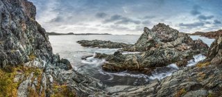 Felsige Küste und Klippen gegen Meerwasser am Tag — Stockfoto