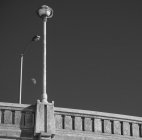 Moon viewed between street light and bridge lamp post; Winnipeg, Manitoba, Canada — Stock Photo