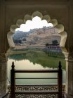 Lago Maota frente al Fuerte Amer visto a través de un arco festoneado; Jaipur, Rajastán, India - foto de stock