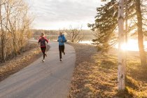 Two young women running on a trail at the water's edge; Anchorage, Alaska, United States of America — Stock Photo