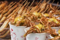 Vista de cerca de los tradicionales mariscos asiáticos fritos en vasos de papel - foto de stock