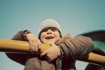 Portrait d'un jeune garçon jouant sur un équipement de terrain de jeu — Photo de stock
