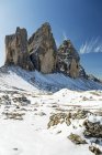 Dramatic mountain spires on top of snow-covered rocky plateau and blue sky; Sesto, Bolzano, Itália — Fotografia de Stock