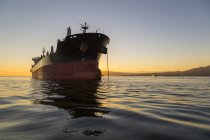 Большой корабль, стоящий на якоре в спокойном Тихом океане у берегов Ванкувера; Ванкувер, Британская Колумбия, Канада — стоковое фото
