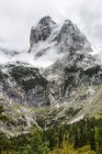 Rugged mountain peak and valley with peak coming through cloud covering and snow; Grainau, Bavaria, Germany — Stock Photo