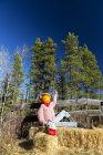 Manichino di Halloween divertente seduto su balle di fieno con testa di zucca e recinzione in legno; Bragg Creek, Alberta, Canada — Foto stock