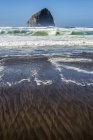Padrões encontrados na praia com uma grande formação rochosa fora da costa, Cape Kiwanda; Pacific City, Oregon, Estados Unidos da América — Fotografia de Stock