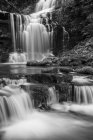 Black and white image of numerous waterfalls flowing over rocks in the Yorkshire Dales; Settle, North Yorkshire, England — Stock Photo