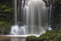 Numerous waterfalls flowing over rocks into a pool in the Yorkshire Dales; Settle, North Yorkshire, England — Stock Photo