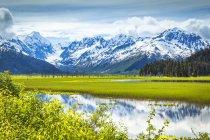 Отражение гор Чугач в спокойном озере; Аляска, Соединенные Штаты Америки — стоковое фото