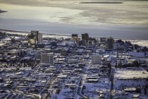 Vista aérea de las avenidas 3, 4, 5 y 6 que corren hacia el oeste hacia el océano a través del centro de Anchorage, hielo marino en Cook Inlet en el fondo, los hoteles Marriot, Hilton y Captain Cook visibles en primer plano, centro-sur de Alaska - foto de stock