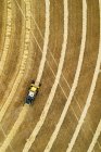 Aerial view directly above a combine collecting lines of grain; Beiseker, Alberta, Canada — Stock Photo