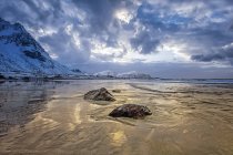 Uma paisagem com montanhas acidentadas e areia ao longo da costa sob um céu nublado; Nordland, Noruega — Fotografia de Stock