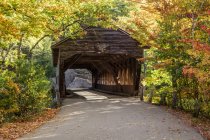 A covered bridge on a back country road in autumn, White Mountains National Forest; New England, United States of America — Stock Photo