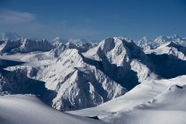 Dramatic landscape of the rugged, snow covered mountain ranges with shadows and blue sky; Haines, Alaska, United States of America — Stock Photo
